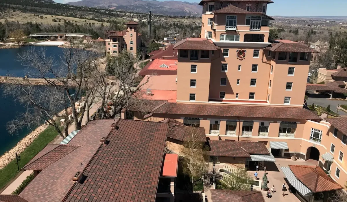 Exploring the Most Common Commercial Roofing Materials. The Broadmoor Hotel with its signature terracotta roofs and scenic mountain backdrop, overlooking a tranquil lake.