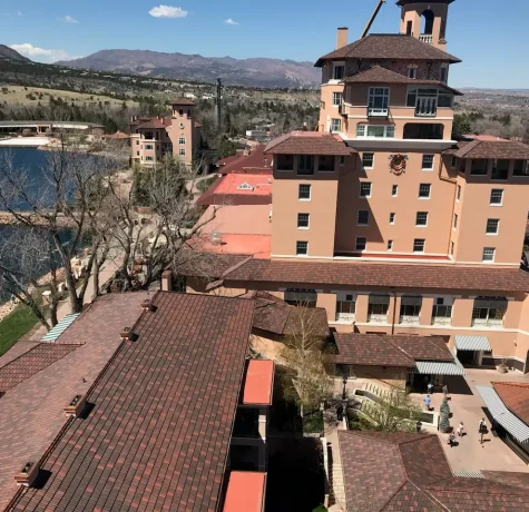 Exploring the Most Common Commercial Roofing Materials. The Broadmoor Hotel with its signature terracotta roofs and scenic mountain backdrop, overlooking a tranquil lake.