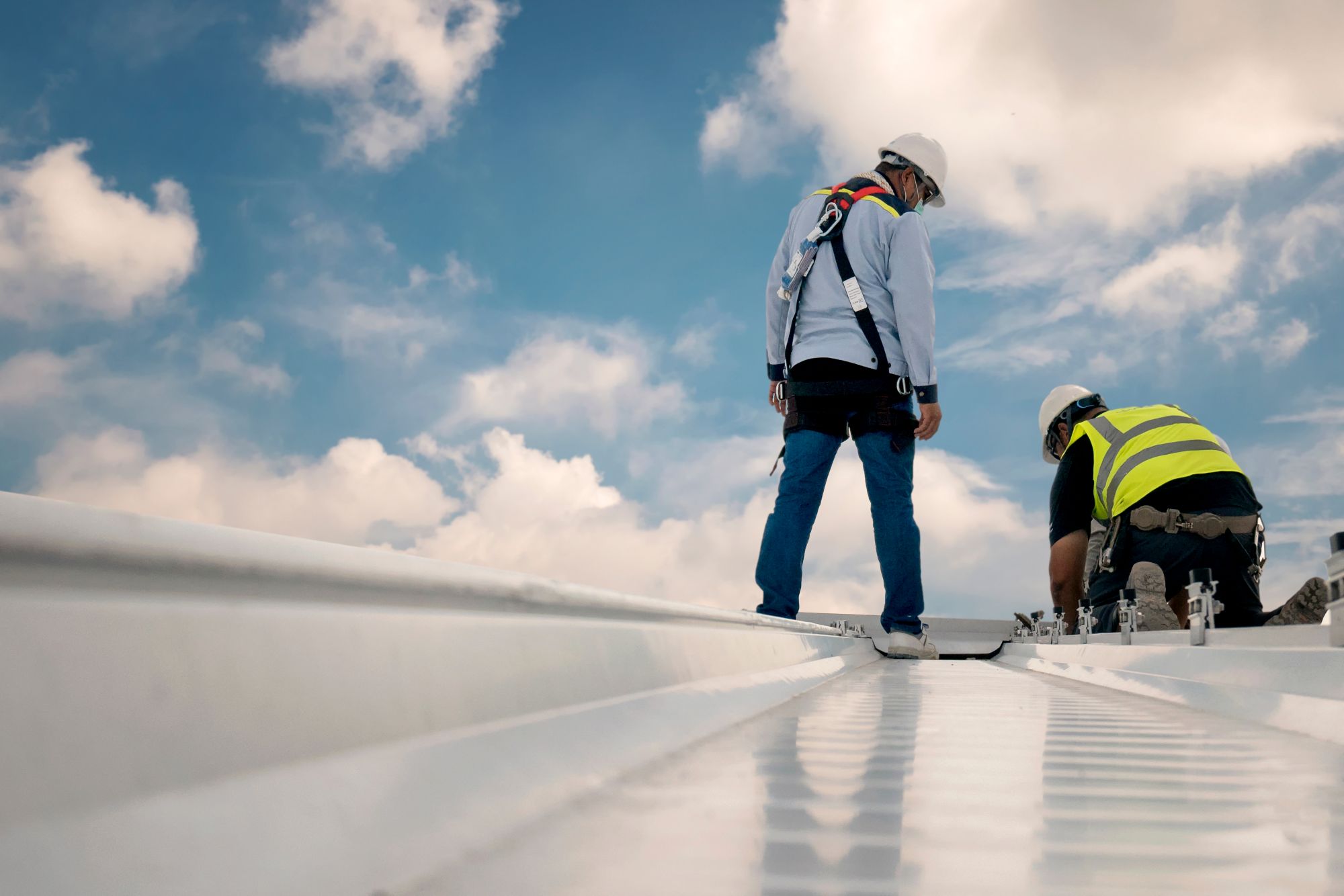 Technician performing reactive maintenance on a commercial flat roof repairing storm damage
