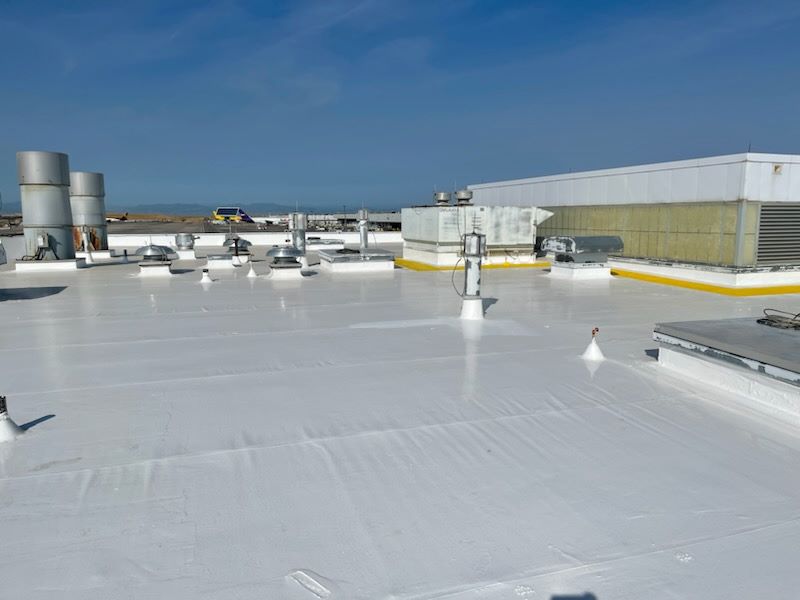 Commercial roofing contractor installing EPDM rubber membrane on a flat roof.