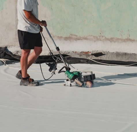 roofing contractor heat-welding seams on TPO membrane