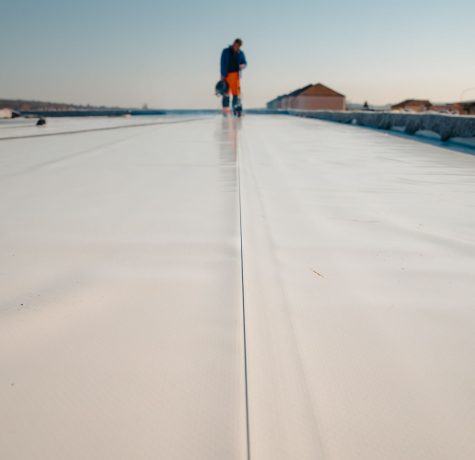 Roof technician repairing seam on TPO membrane