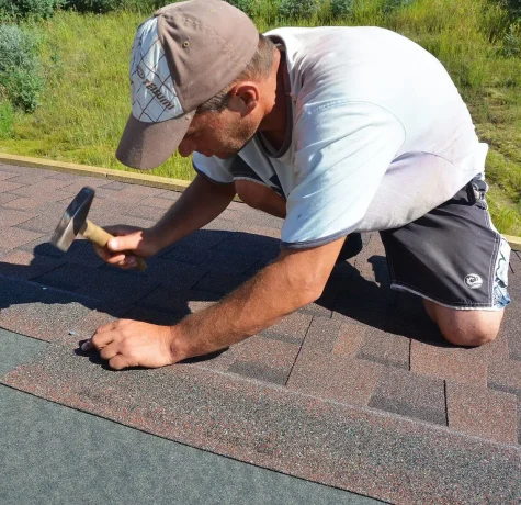 Technician performing maintenance inspection on a low-slope commercial roof.