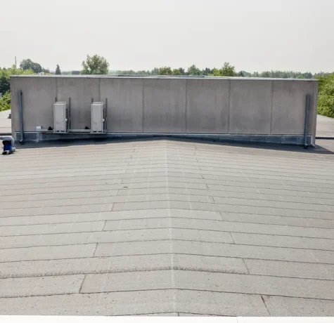 Commercial flat roof showing cracks, seams, and weather-related damage.