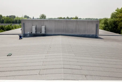 Commercial flat roof showing cracks, seams, and weather-related damage.