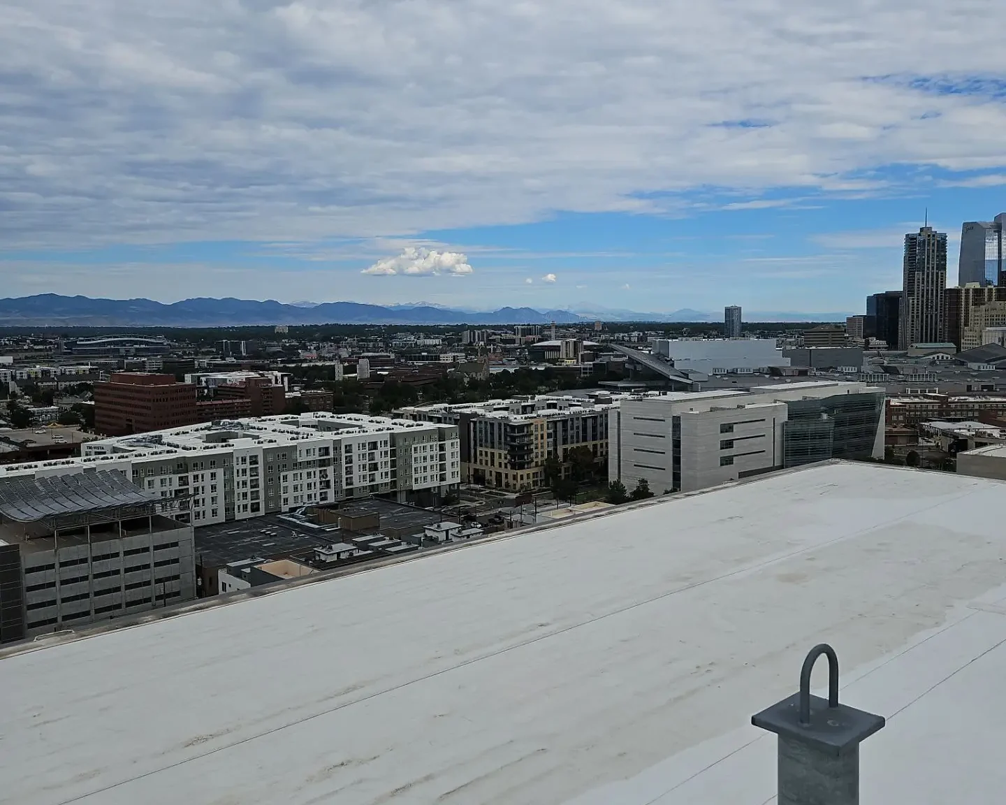 White TPO roofing system with roof drain and penetration details at a Denver multifamily property.