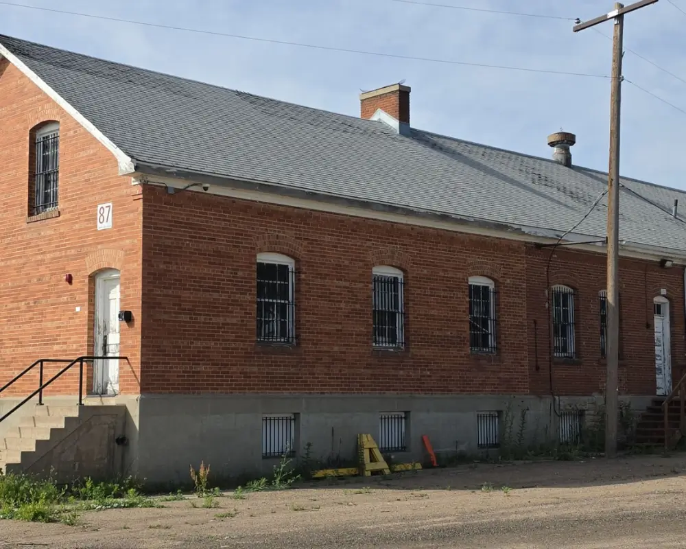 Historic DHS Building 87 at Fort Logan before its roof replacement, showing the aging roof