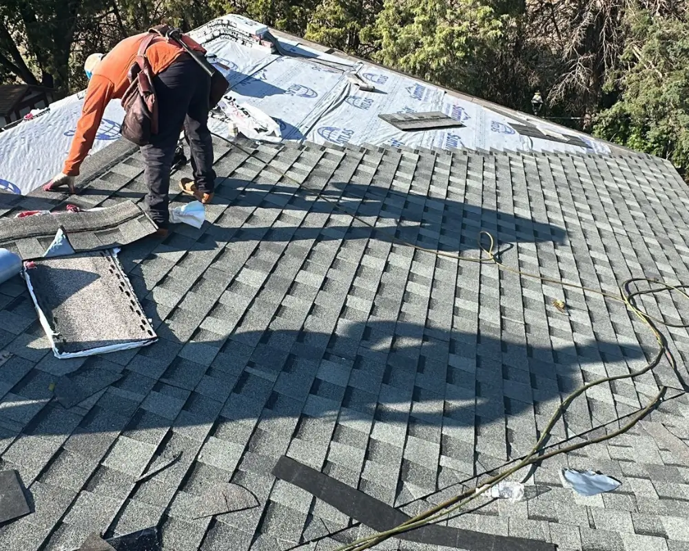 Roofing crew installing new asphalt shingles during a residential roof replacement in McPherson, KS.