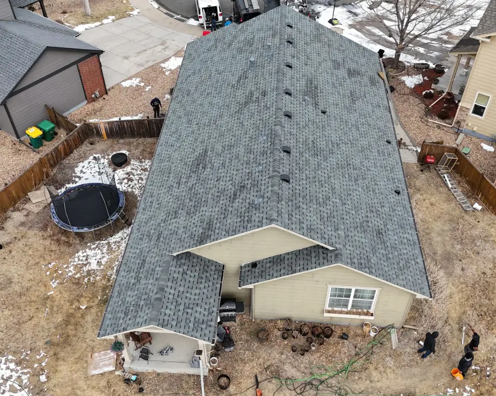 Close aerial view of newly installed gray asphalt shingles and roof vents