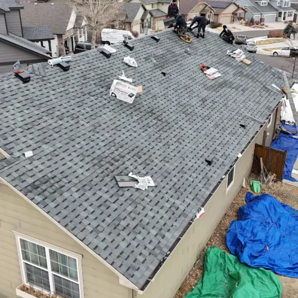 Roofing crew installing new asphalt shingles on Castle Rock home