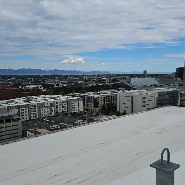 White TPO roofing system with roof drain and penetration details at a Denver multifamily property.