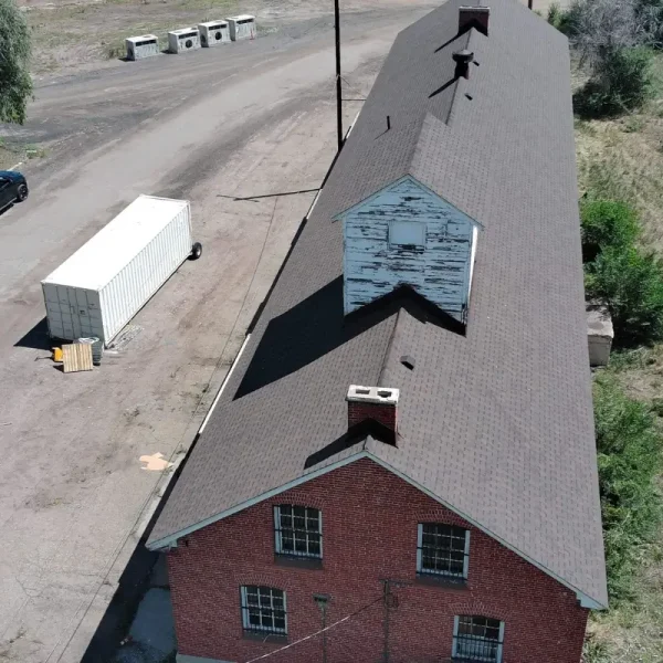 Completed architectural shingle roof on historic DHS Building 87 at Fort Logan in Denver, Colorado