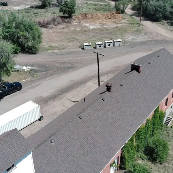 New shingle roof over the historic red brick gable and dormer of DHS Building 87 at Fort Logan