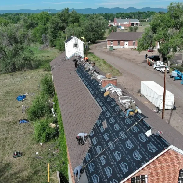 Premier crew installing synthetic underlayment during the DHS Building 87 reroof at Fort Logan