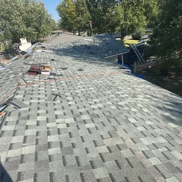 New asphalt shingles being installed over synthetic underlayment on a McPherson, Kansas home.