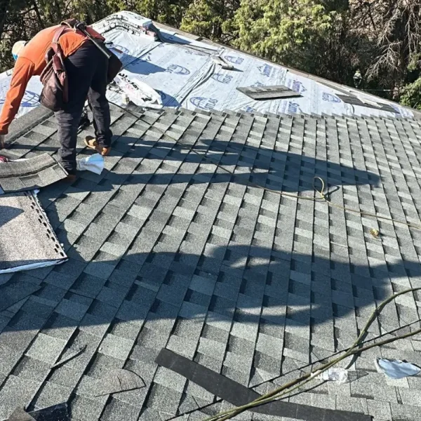 Roofing crew installing new asphalt shingles during a residential roof replacement in McPherson, KS.