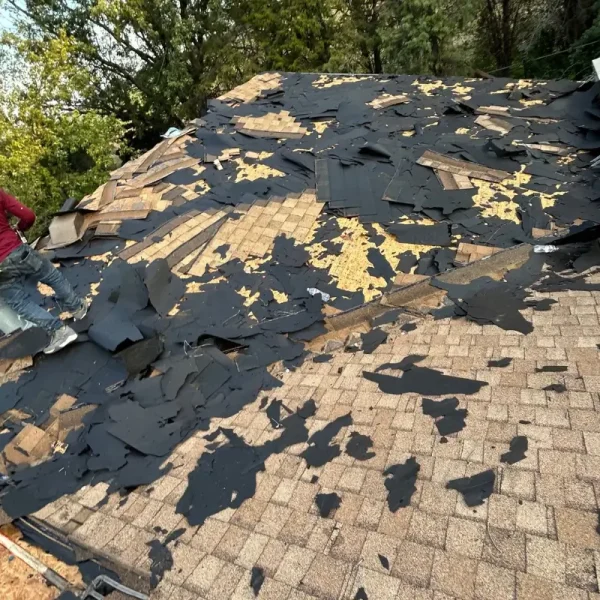 Existing asphalt shingles being removed during a full residential roof replacement in McPherson, Kansas.