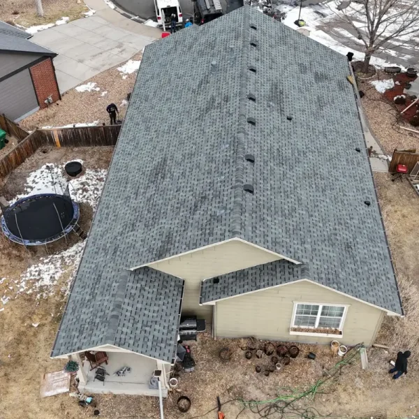 Close aerial view of newly installed gray asphalt shingles and roof vents