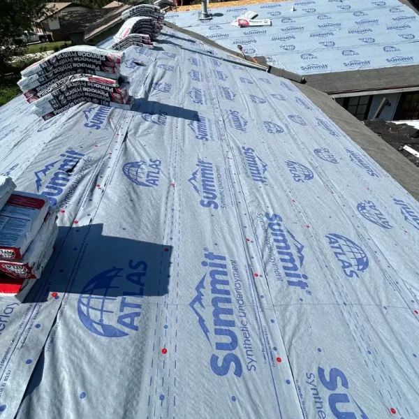 Atlas Pinnacle Pristine shingles staged over synthetic underlayment during a McPherson roof replacement.
